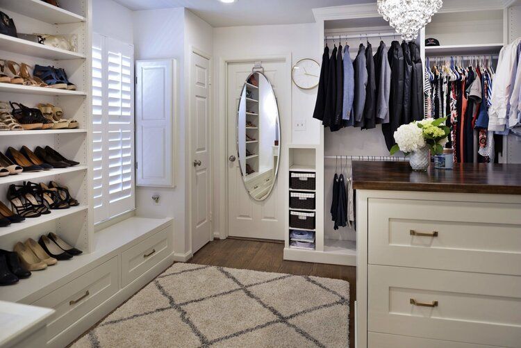 A walk in closet filled with lots of clothes and shoes.
