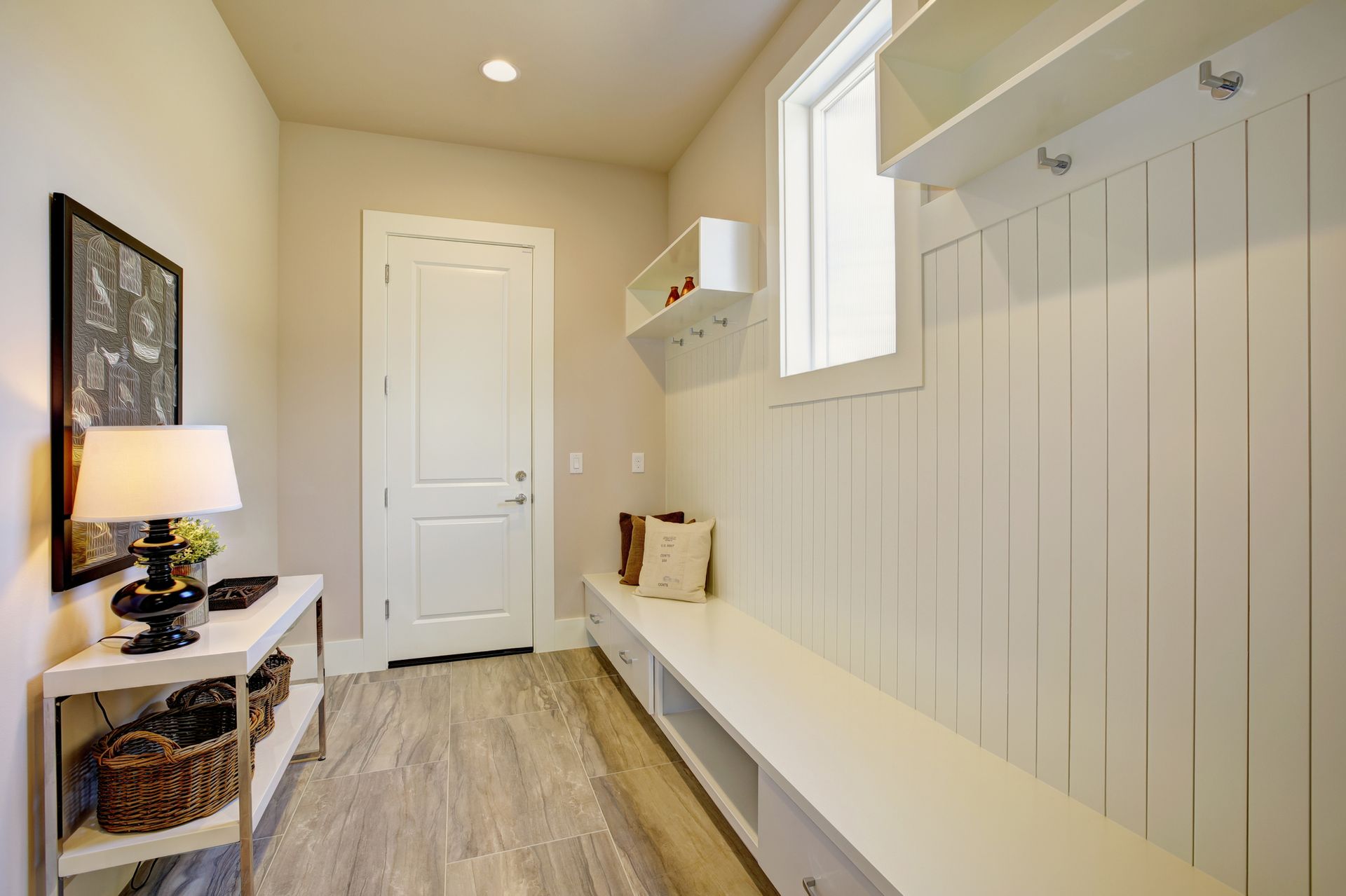 A hallway with a bench and a window in a house.