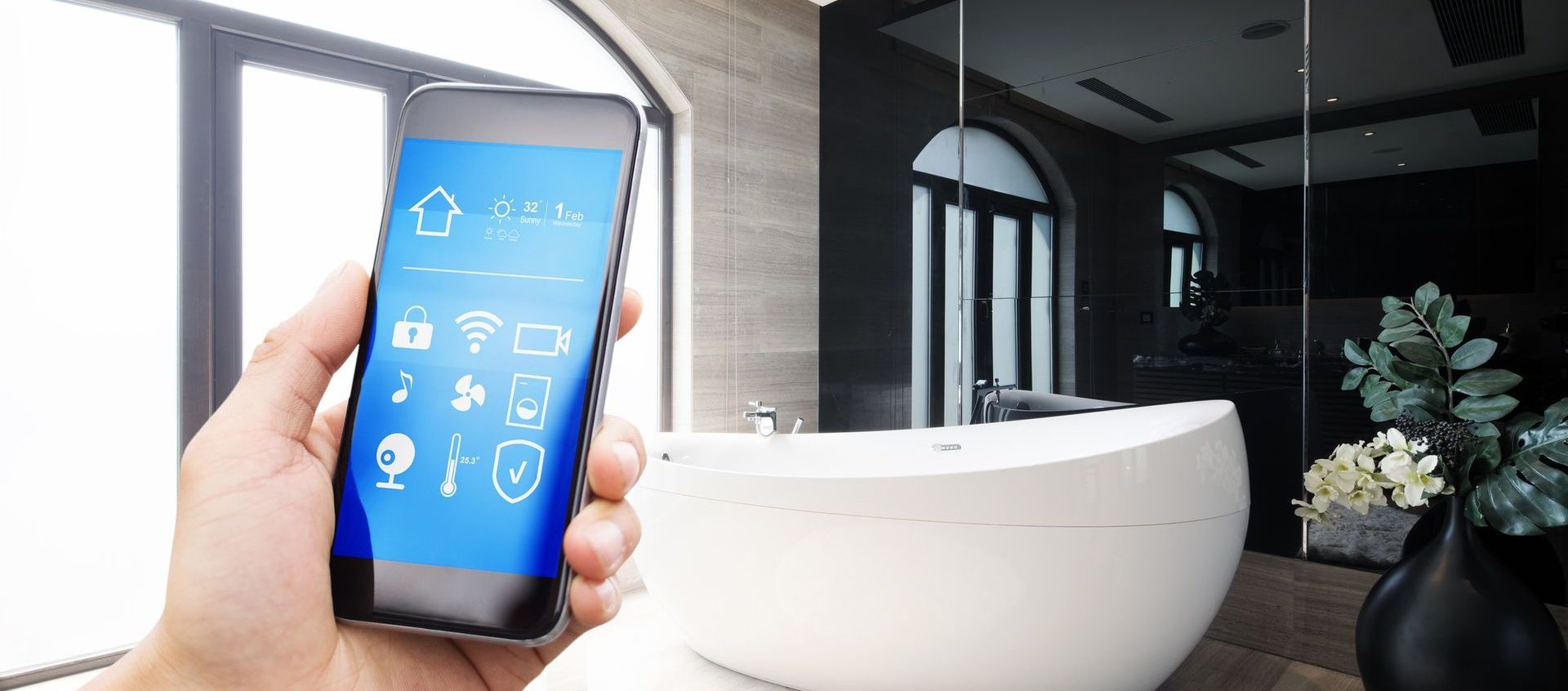 A person is holding a smart phone in a bathroom.