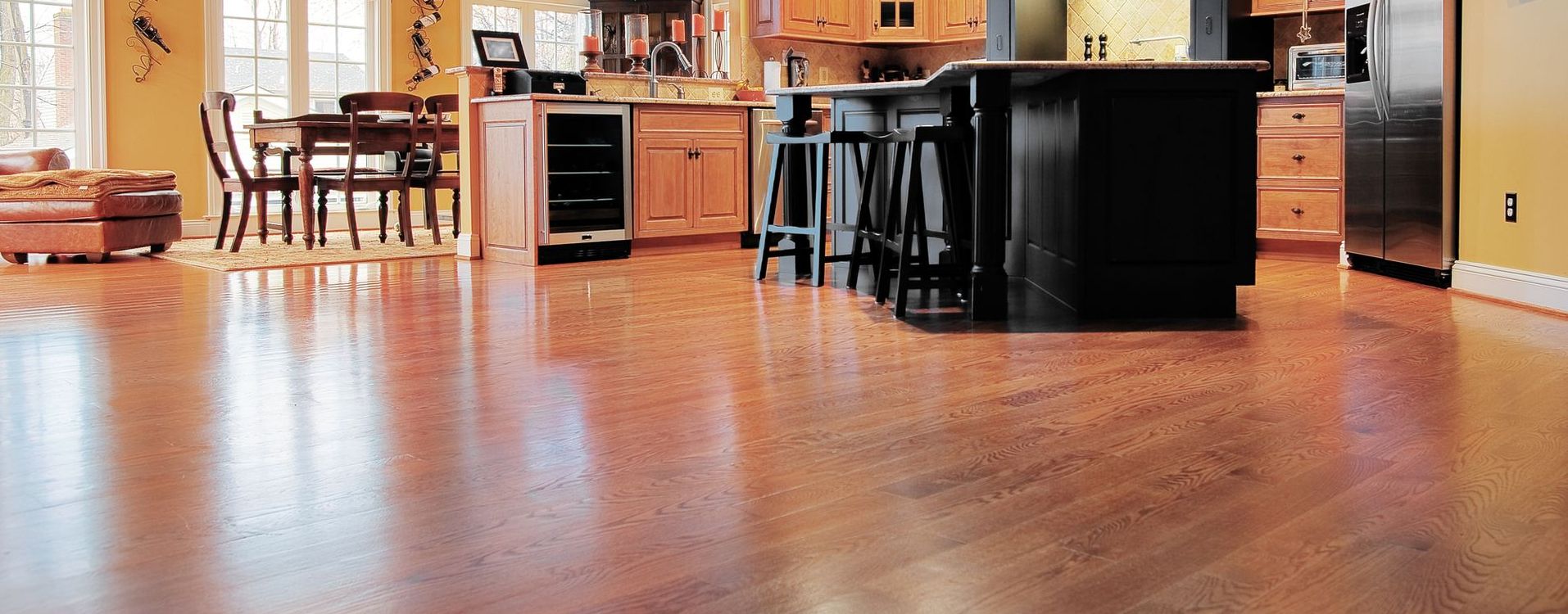 A kitchen with a wooden floor and a black island