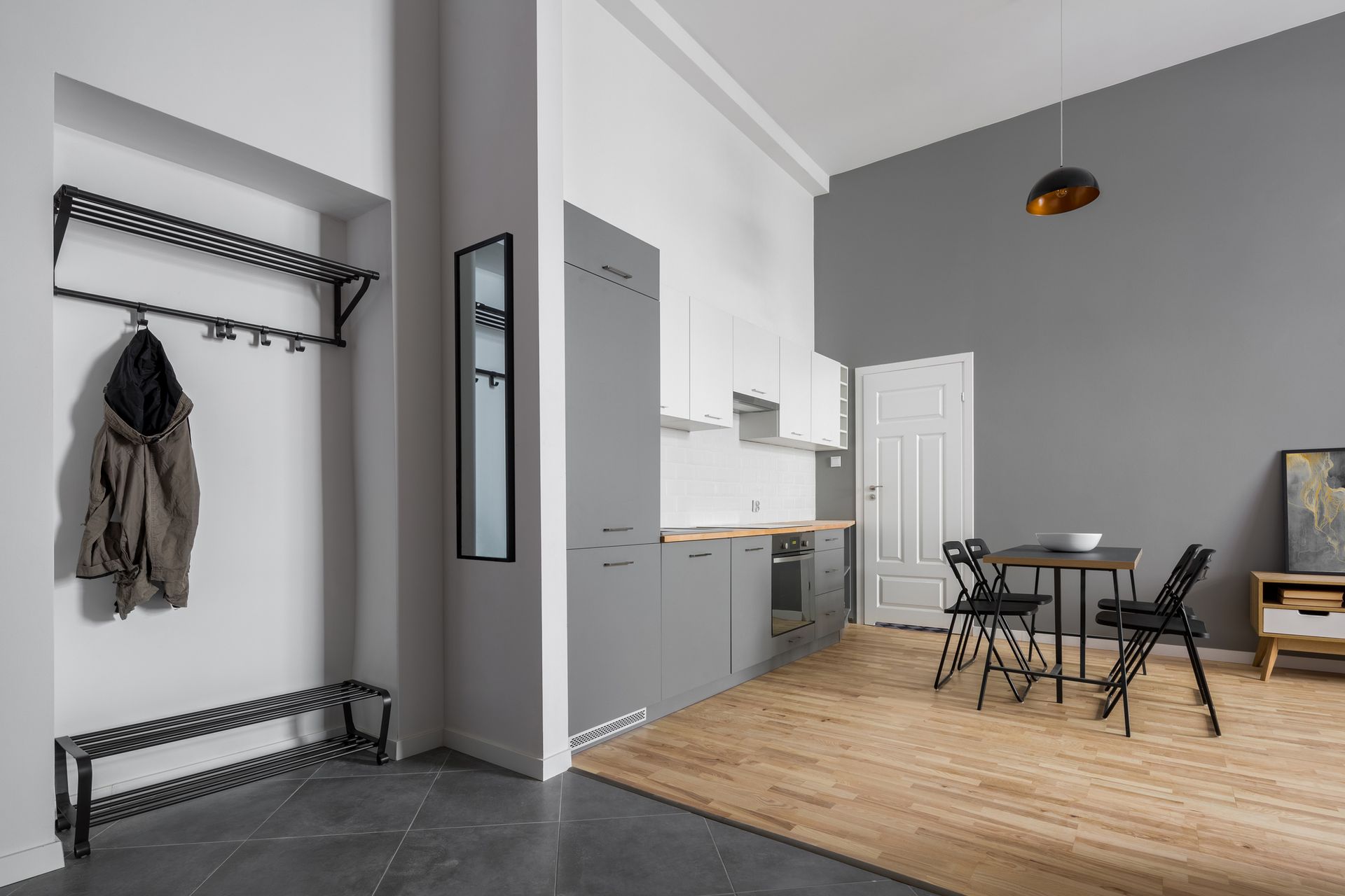 A living room with a table and chairs and a coat rack.