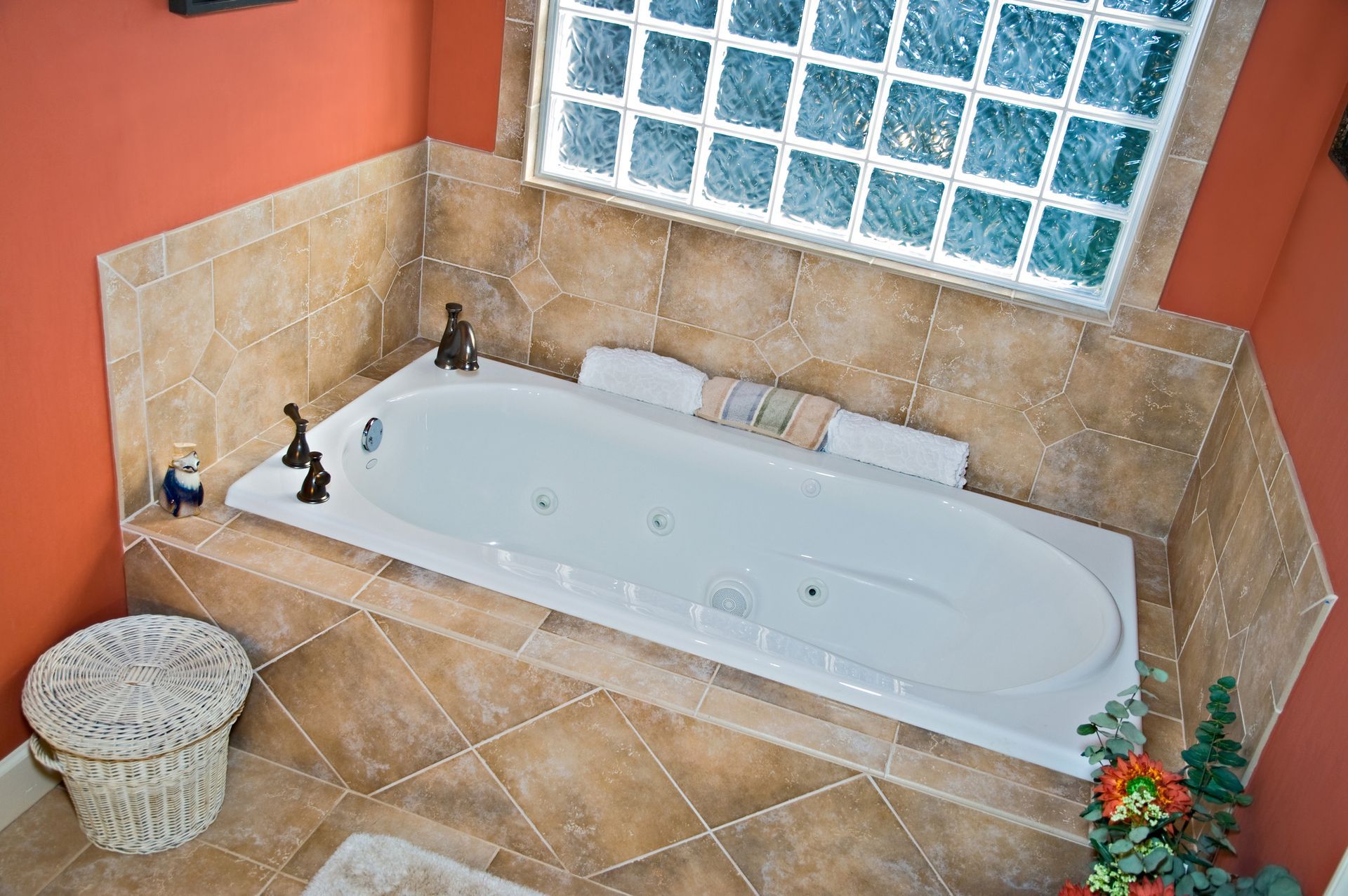 A bathtub in a bathroom with a window above it