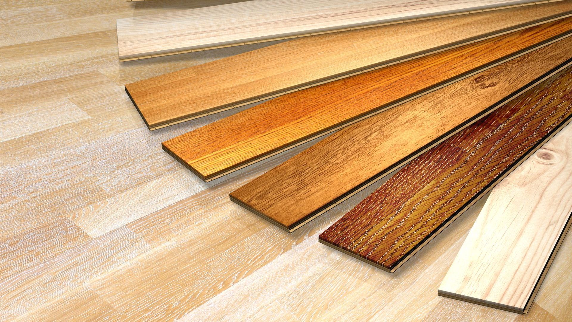 A bunch of wooden boards are stacked on top of each other on a wooden floor.