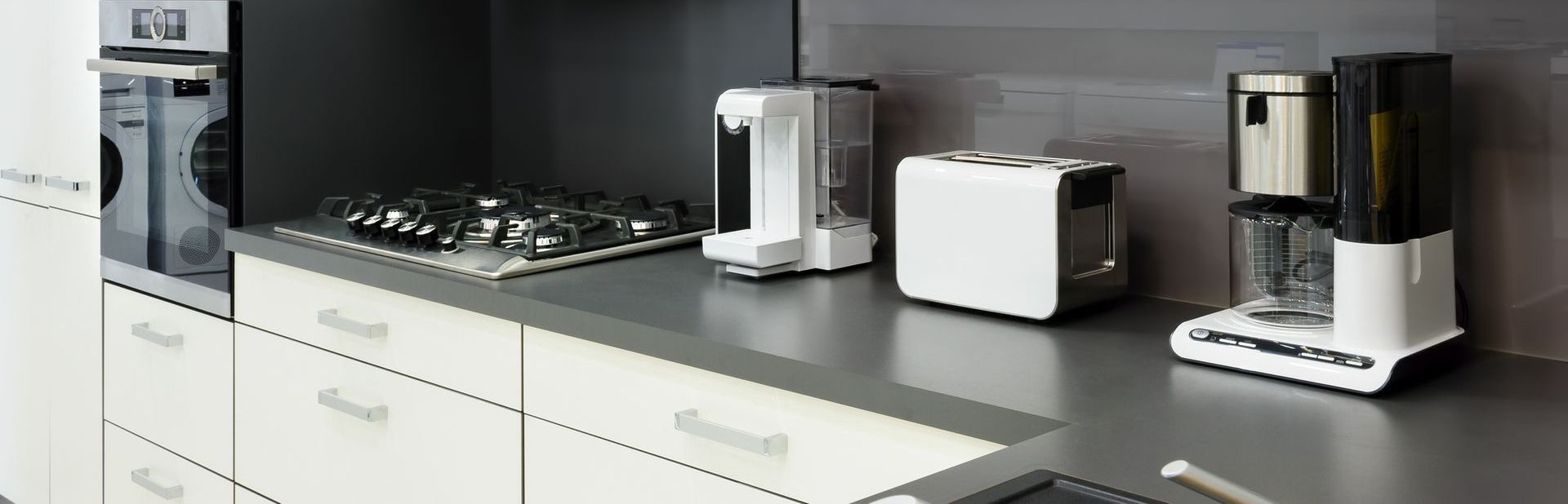 A kitchen counter with a toaster and coffee maker on it.