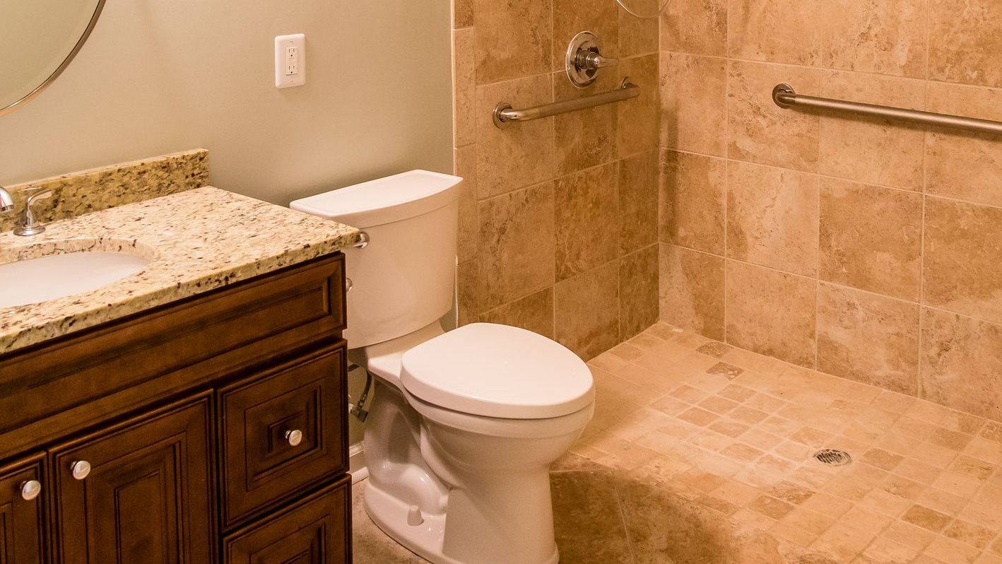 A bathroom with a toilet , sink , and walk in shower.