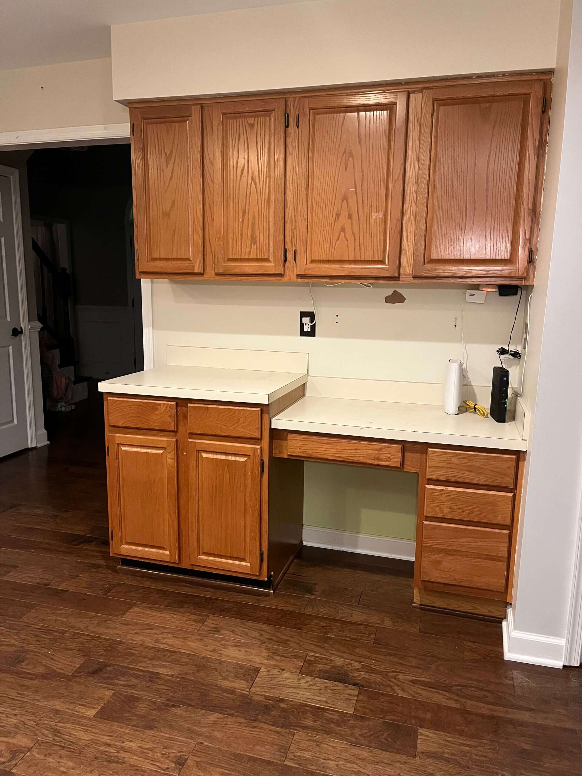 A kitchen with wooden cabinets and a white counter top.