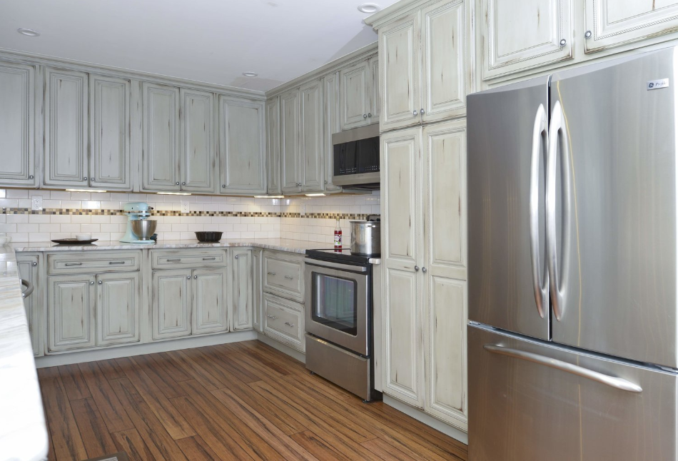 A kitchen with stainless steel appliances and white cabinets.