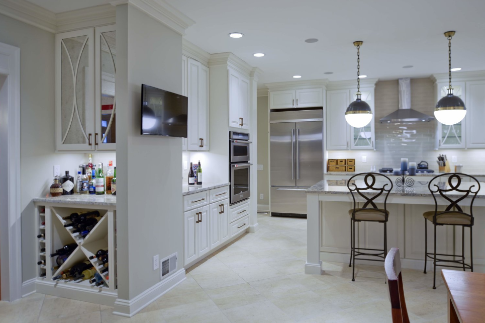 A kitchen with white cabinets and stainless steel appliances and a wine rack.