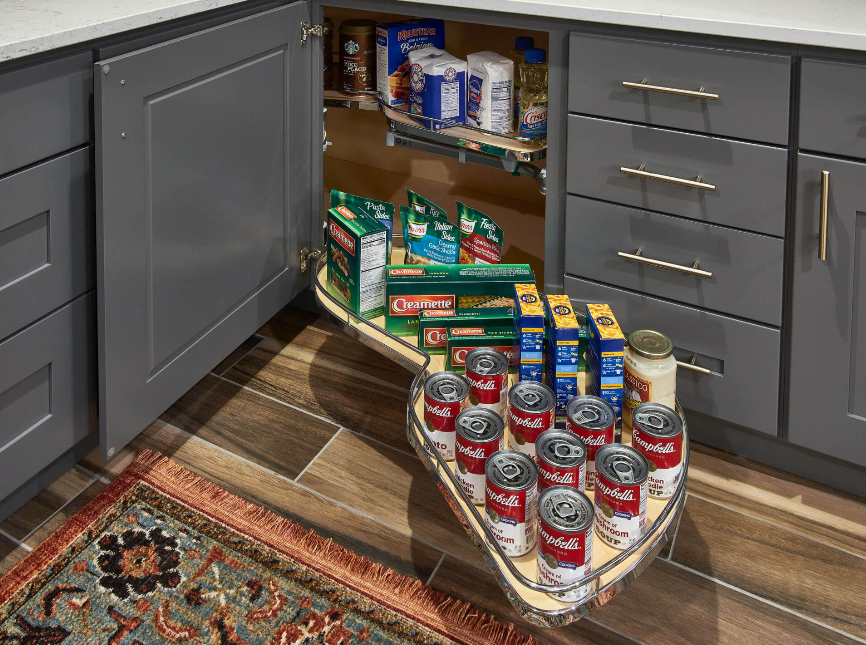 A kitchen with a sliding pantry filled with canned food.