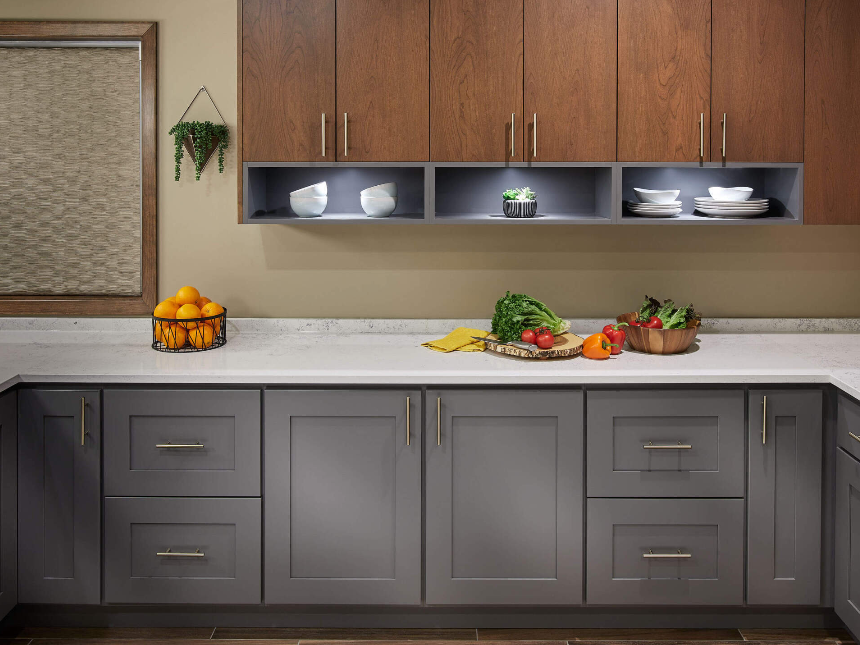 A kitchen with gray cabinets and wooden cabinets