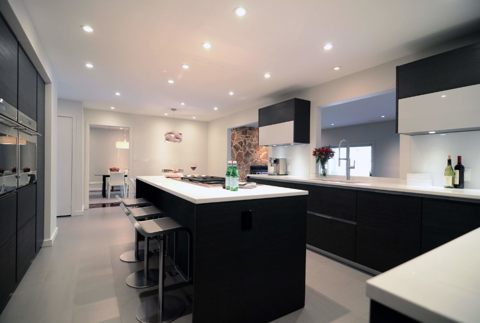 A kitchen with black cabinets and white counter tops