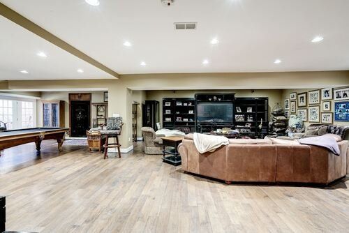 A living room with a couch , pool table , and television.