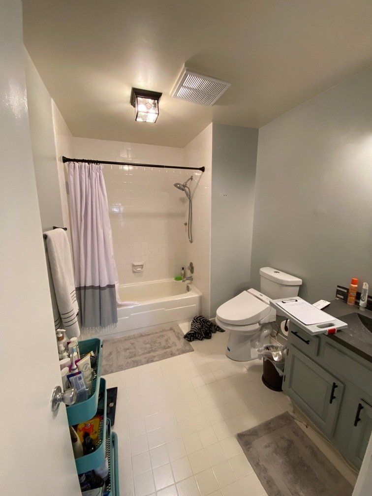 A bathroom with a toilet , sink , tub and shower.