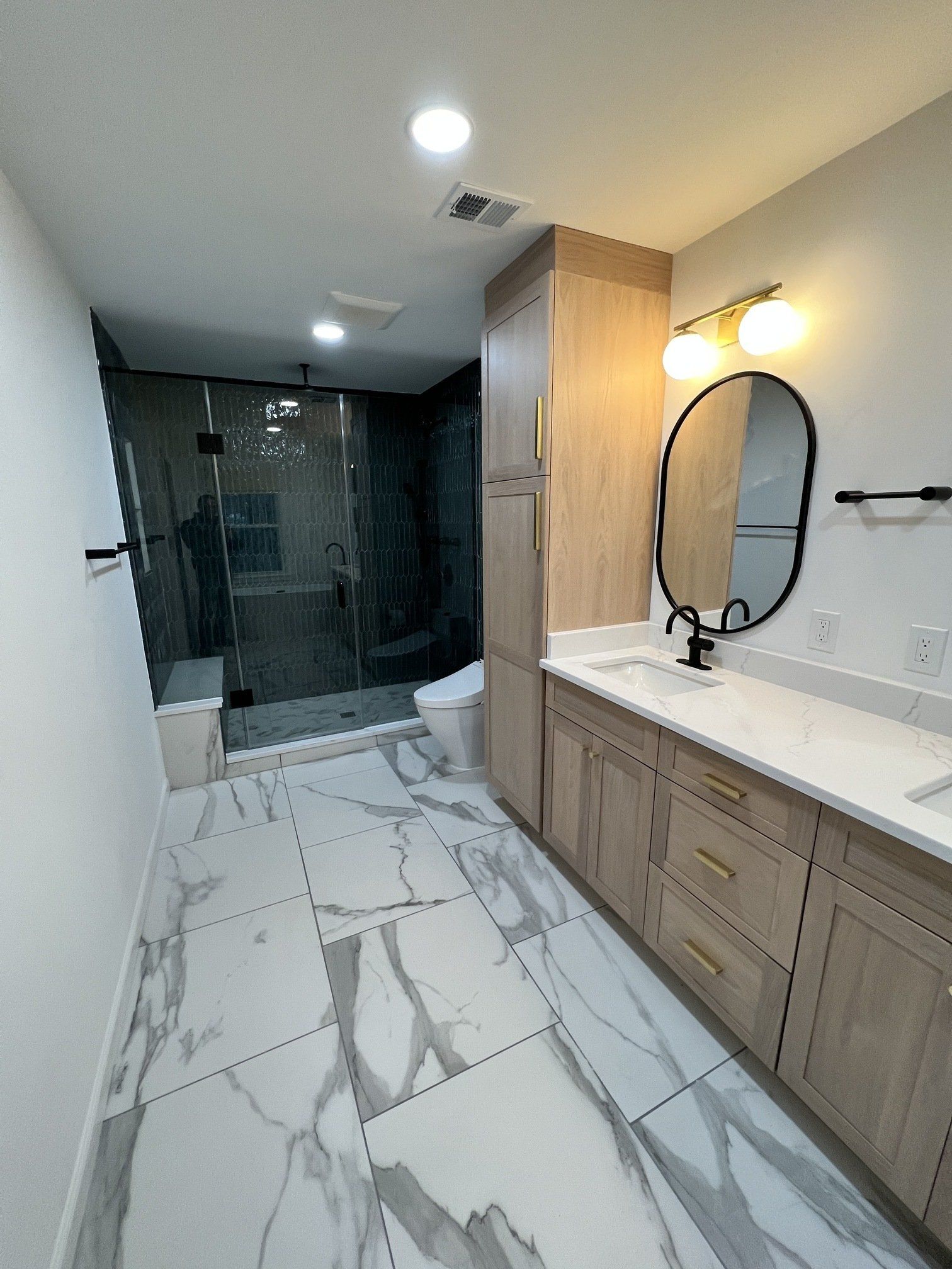A bathroom with two sinks , a toilet , and a mirror.