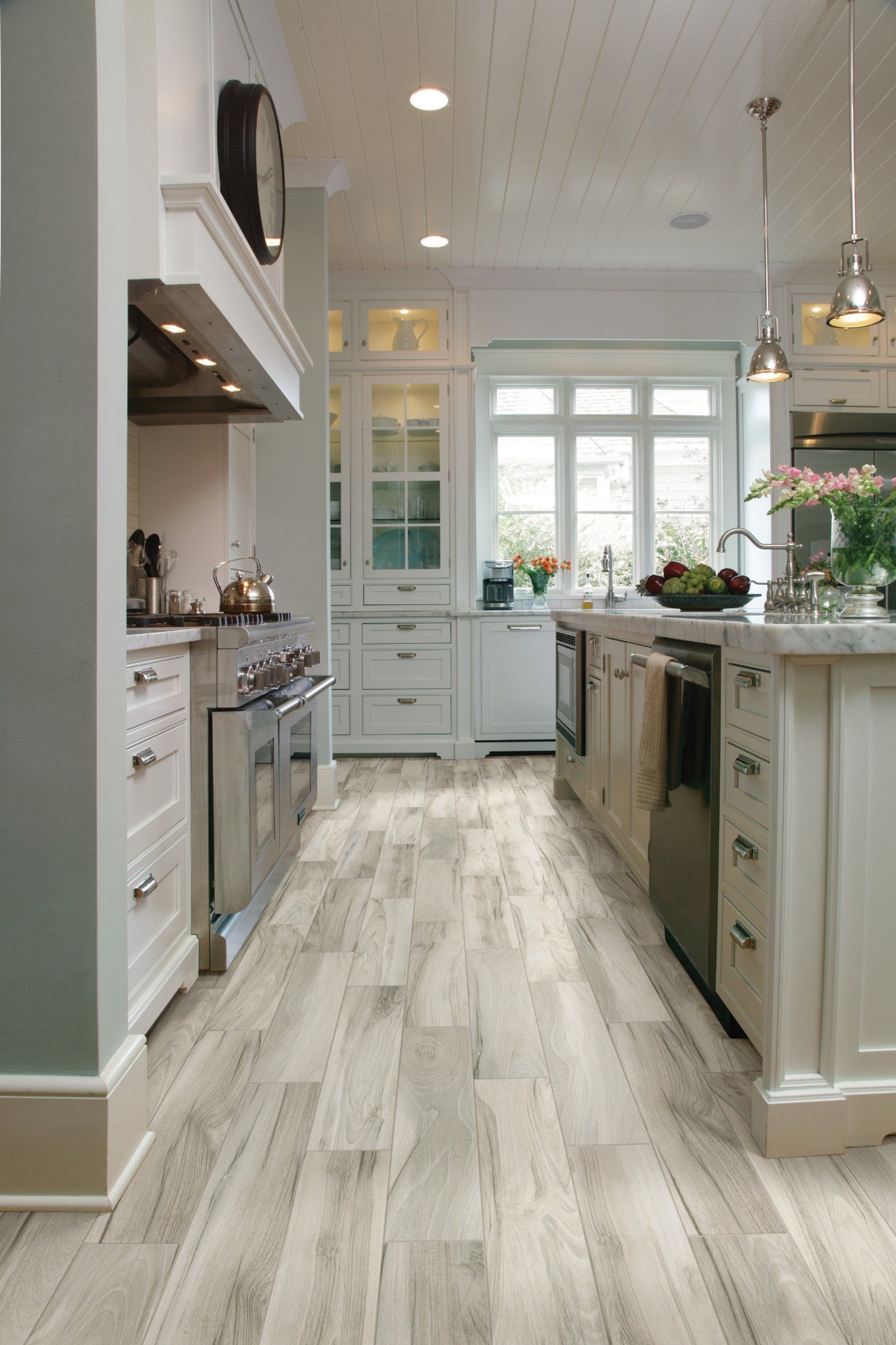 A kitchen with a wooden floor and white cabinets.