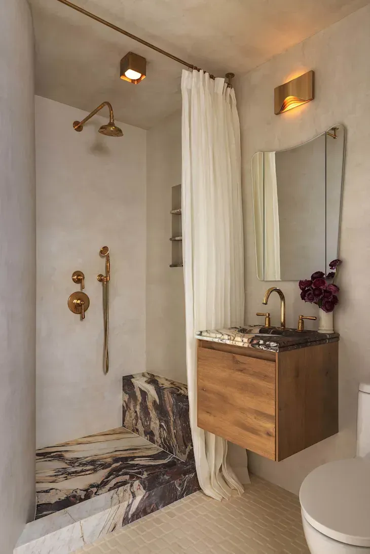 A bathroom with two sinks , a tub , and a mirror.