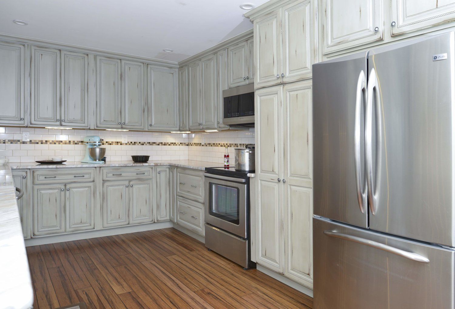 A kitchen with stainless steel appliances and white cabinets.