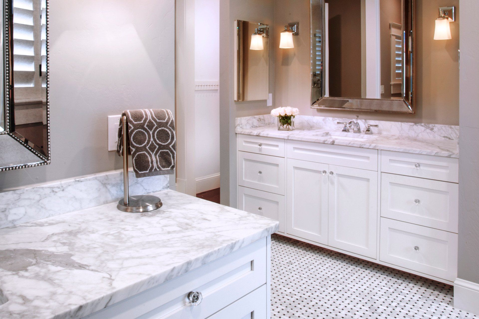 A bathroom with white cabinets and marble counter tops