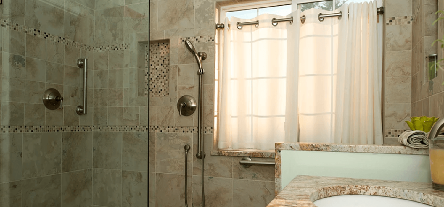 A bathroom with a sink , shower , and window.