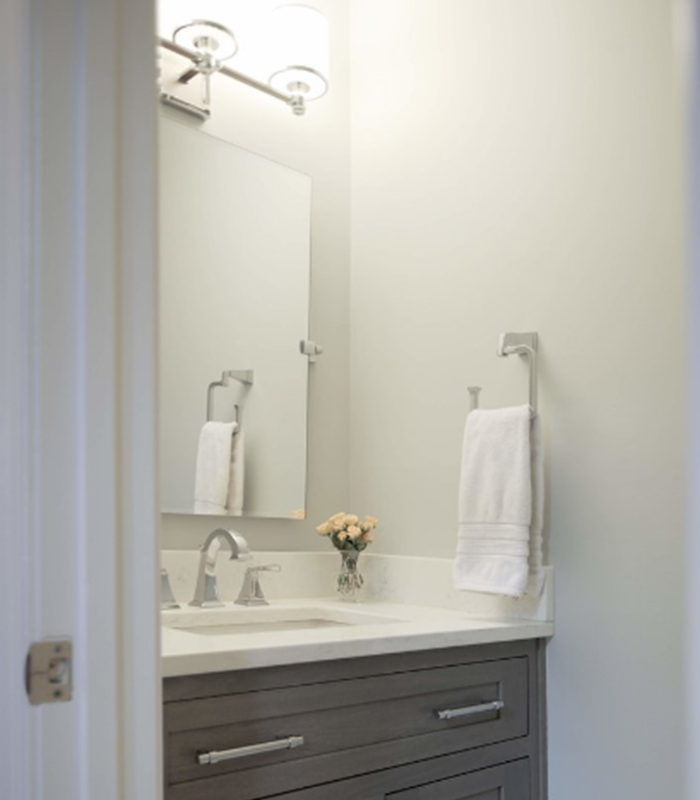 A bathroom with a sink a mirror and a towel rack