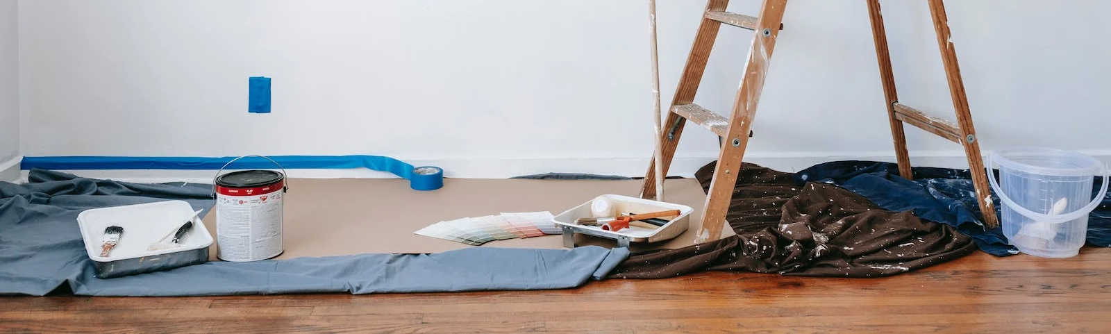 A room is being painted and a ladder is sitting on the floor.