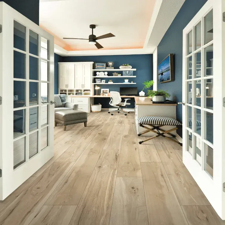 A living room with a dresser a chair and a plant