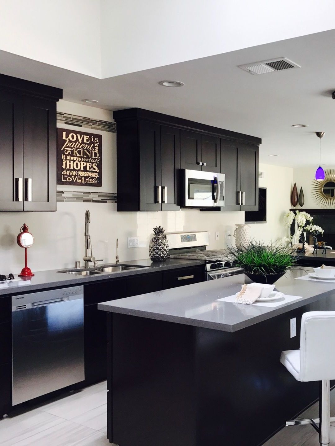 A kitchen with black cabinets and stainless steel appliances