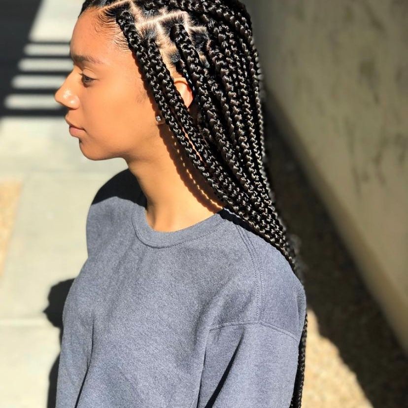 A woman with braids is wearing a blue shirt