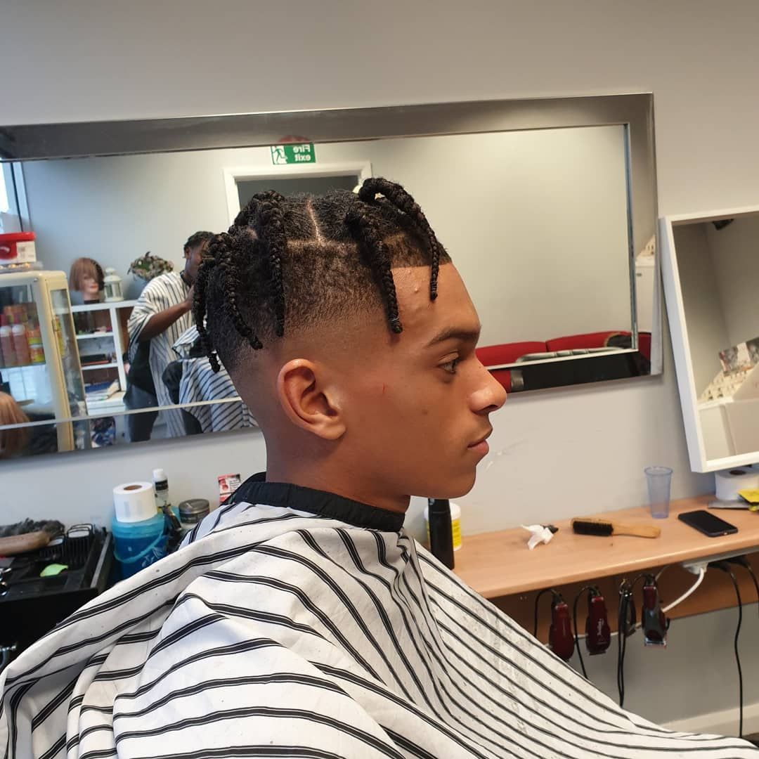 A man is getting his hair cut at a barber shop.