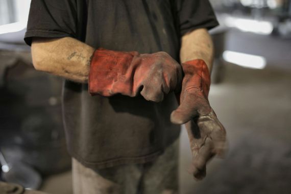 Person wearing red work gloves, preparing for a task indoors.