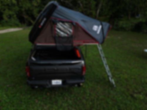 Truck showcasing a sturdy bed rack and roof top tent for camping
