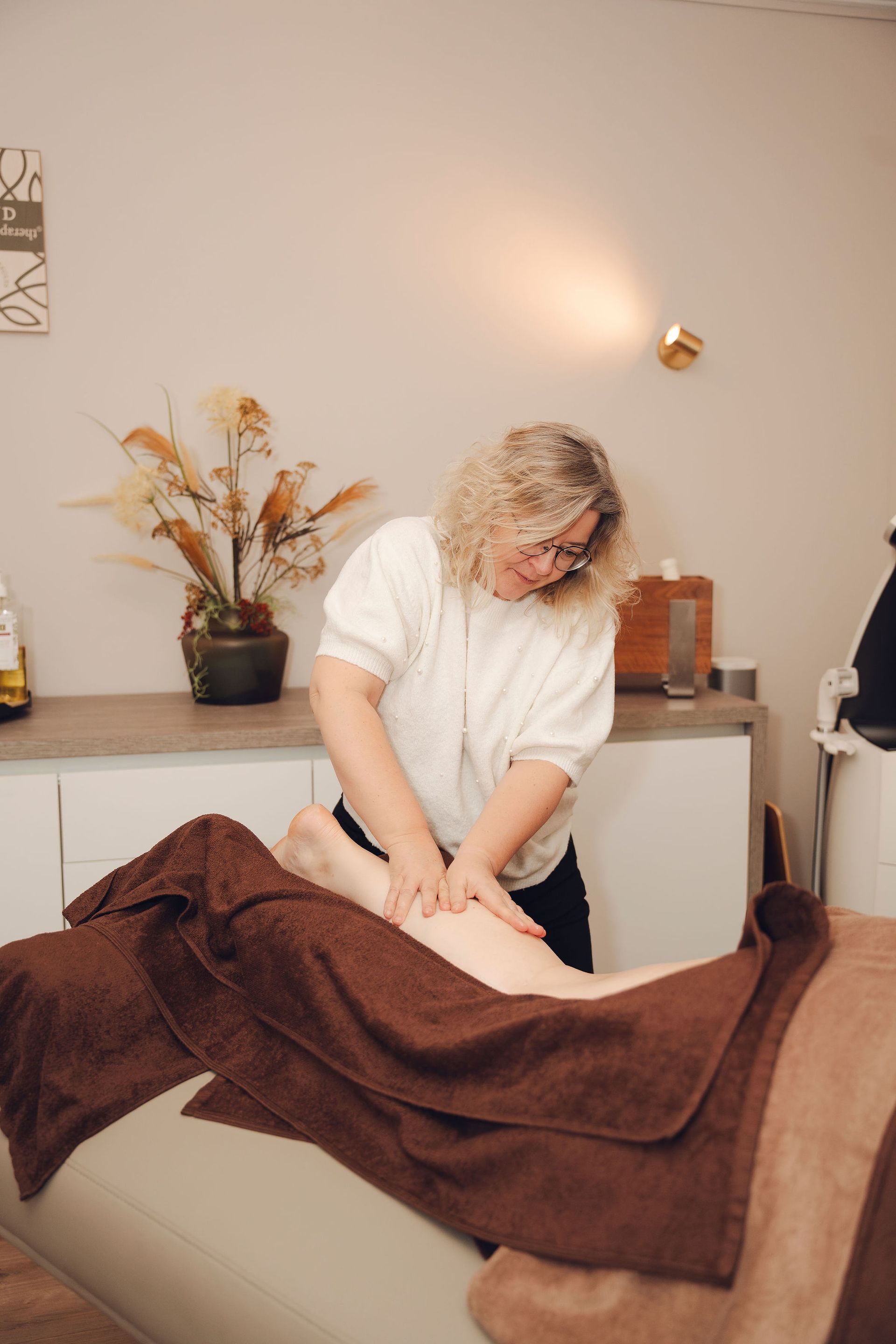 Een vrouw geeft een massage aan een andere vrouw in een spa.