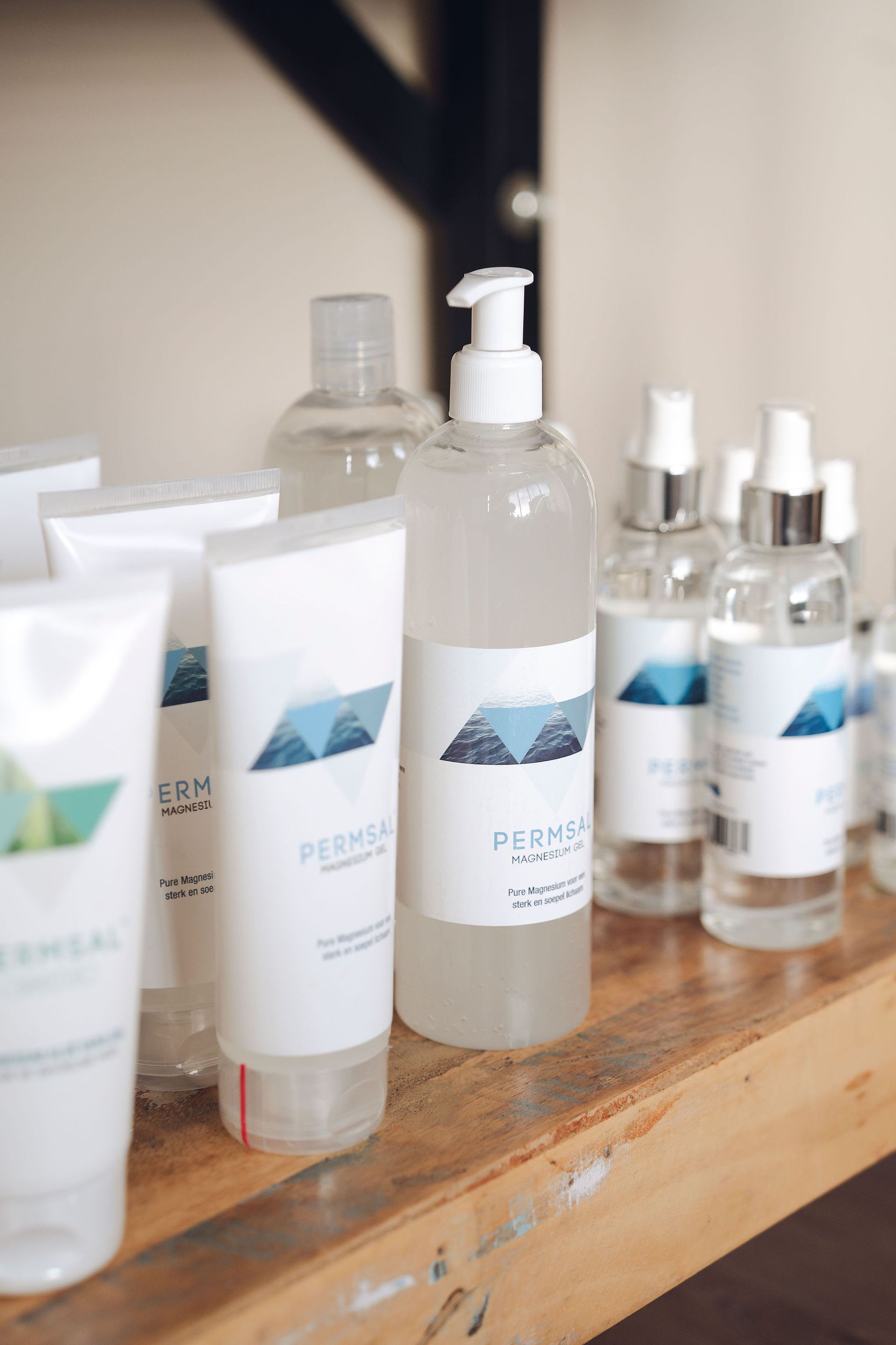 Een houten plank vol met flesjes en tubes Permsal magnesium.