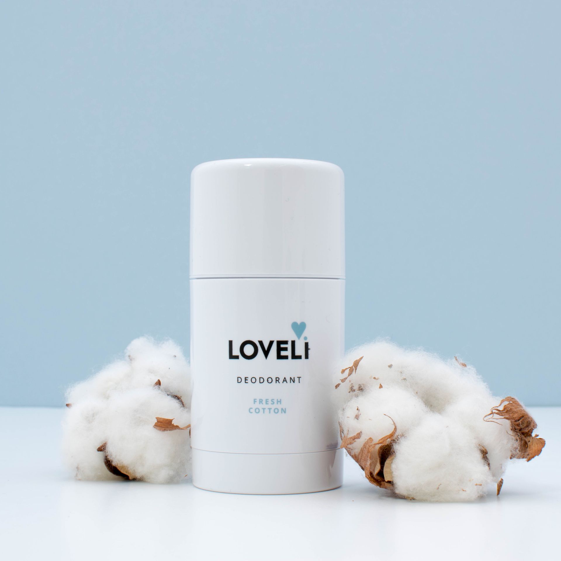 Een fles Loveli-deodorant staat op een wit oppervlak.