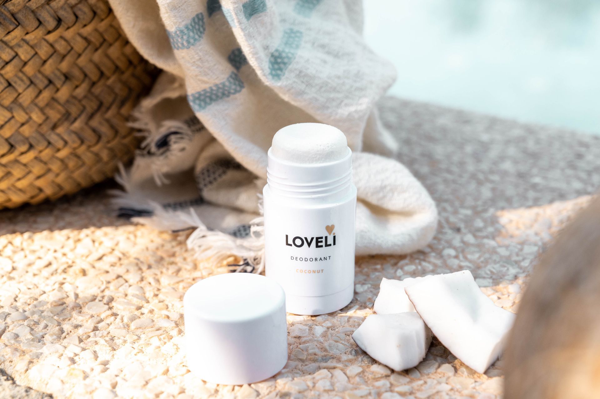 Een fles loveli deodorant naast een kokosnoot