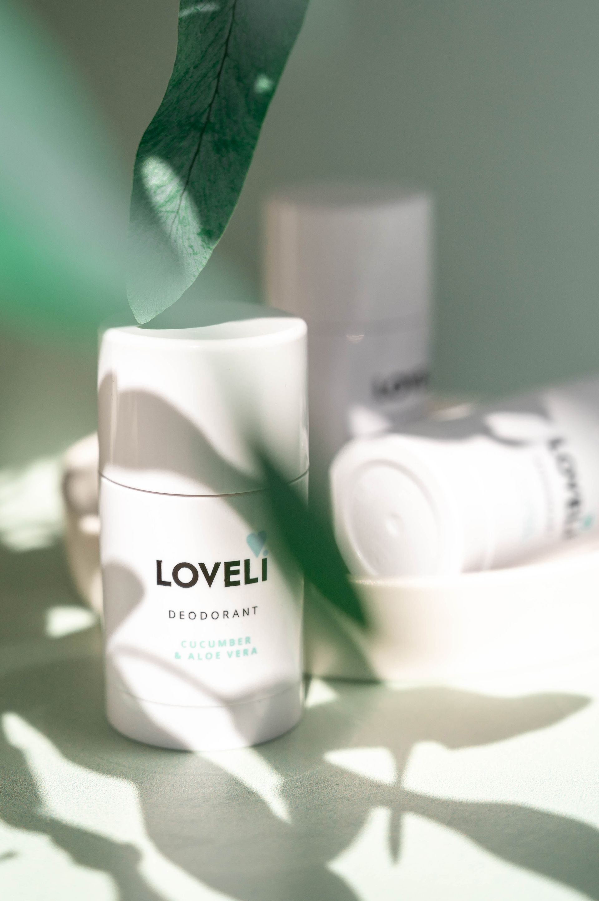 Een fles Loveli deodorant staat op een tafel.