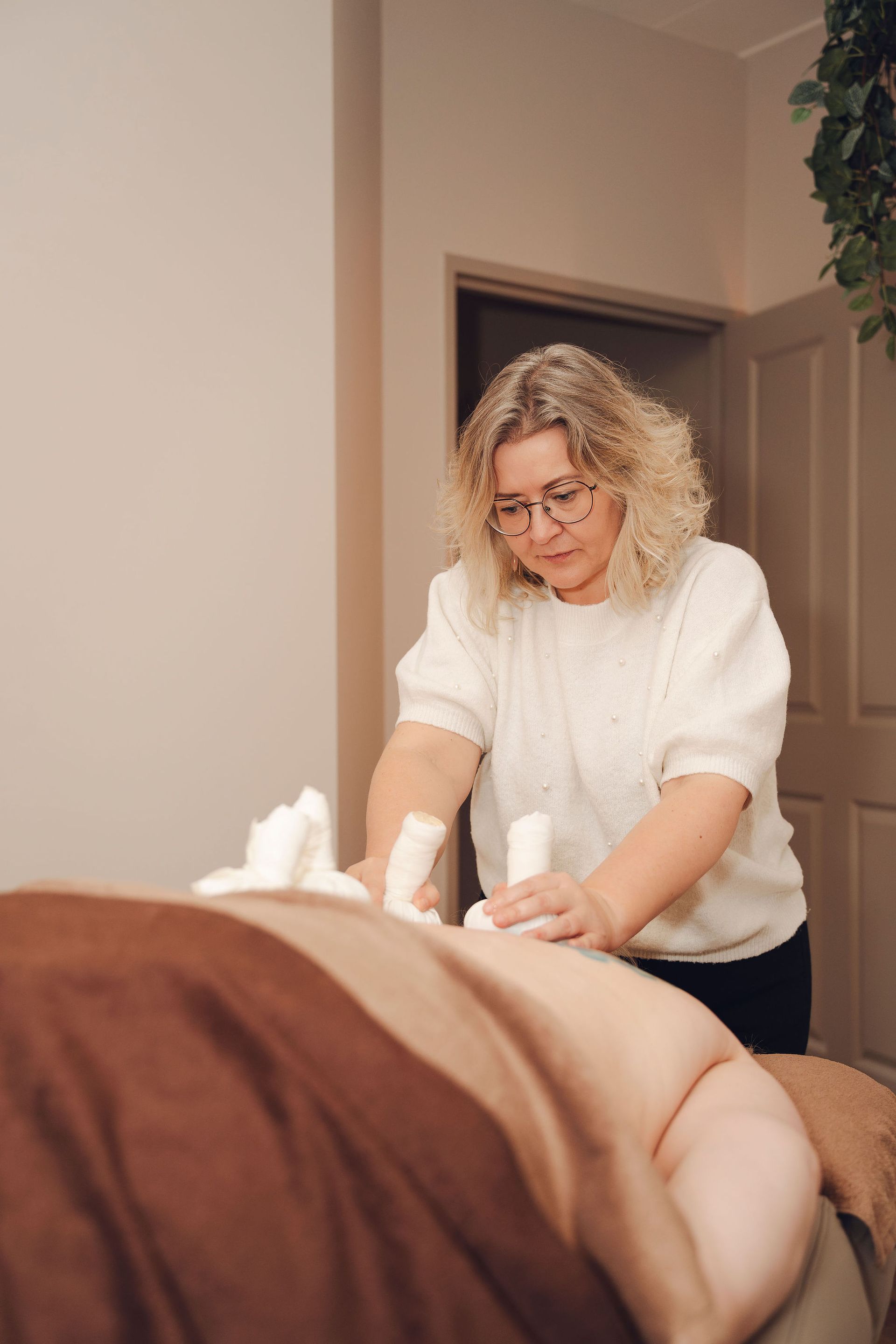Een vrouw geeft een massage aan een man in een kamer.
