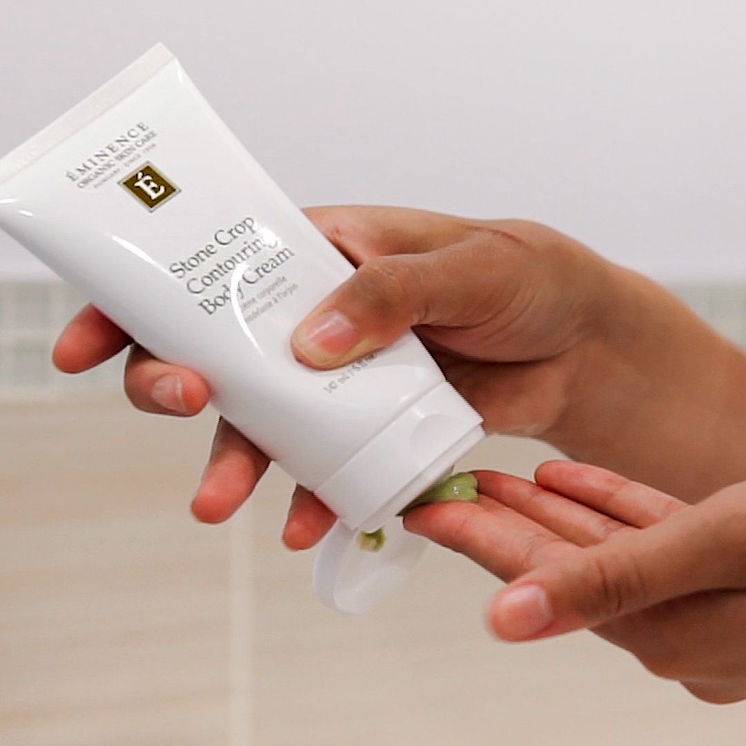 Een persoon houdt een tube essence body cream vast
