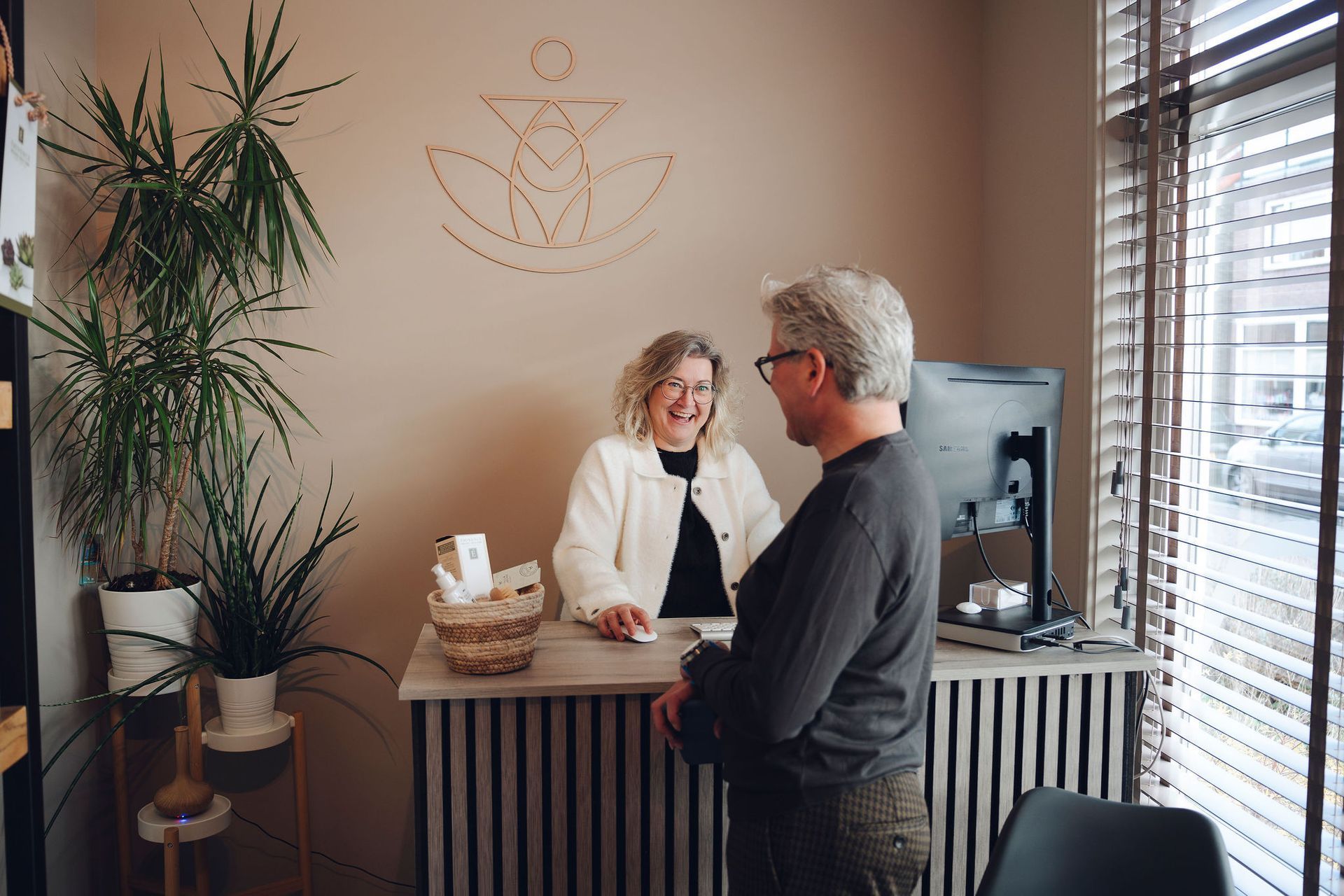 Een man praat met een vrouw aan de balie in een kamer.