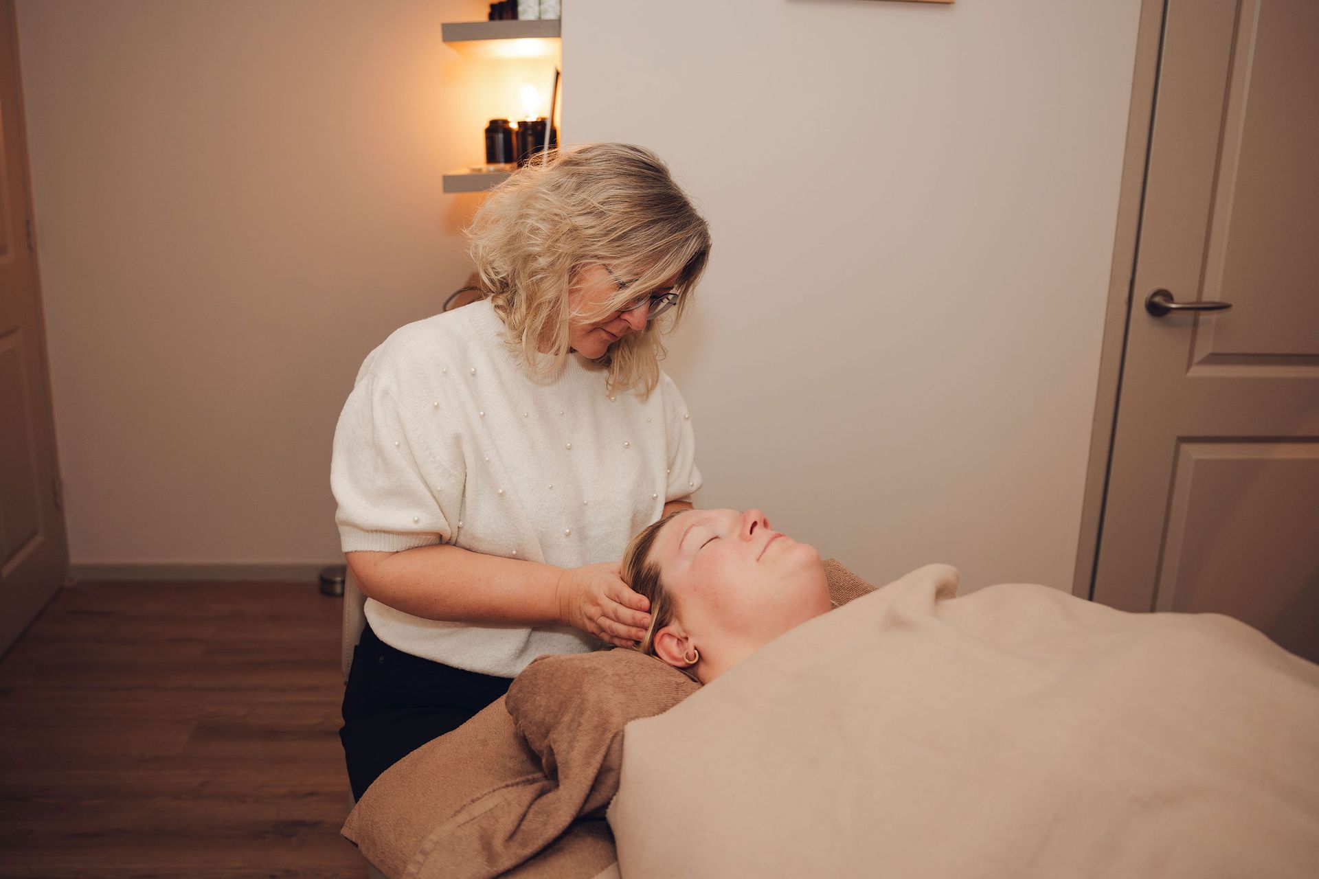 Een vrouw geeft een vrouw een massage in een kamer.