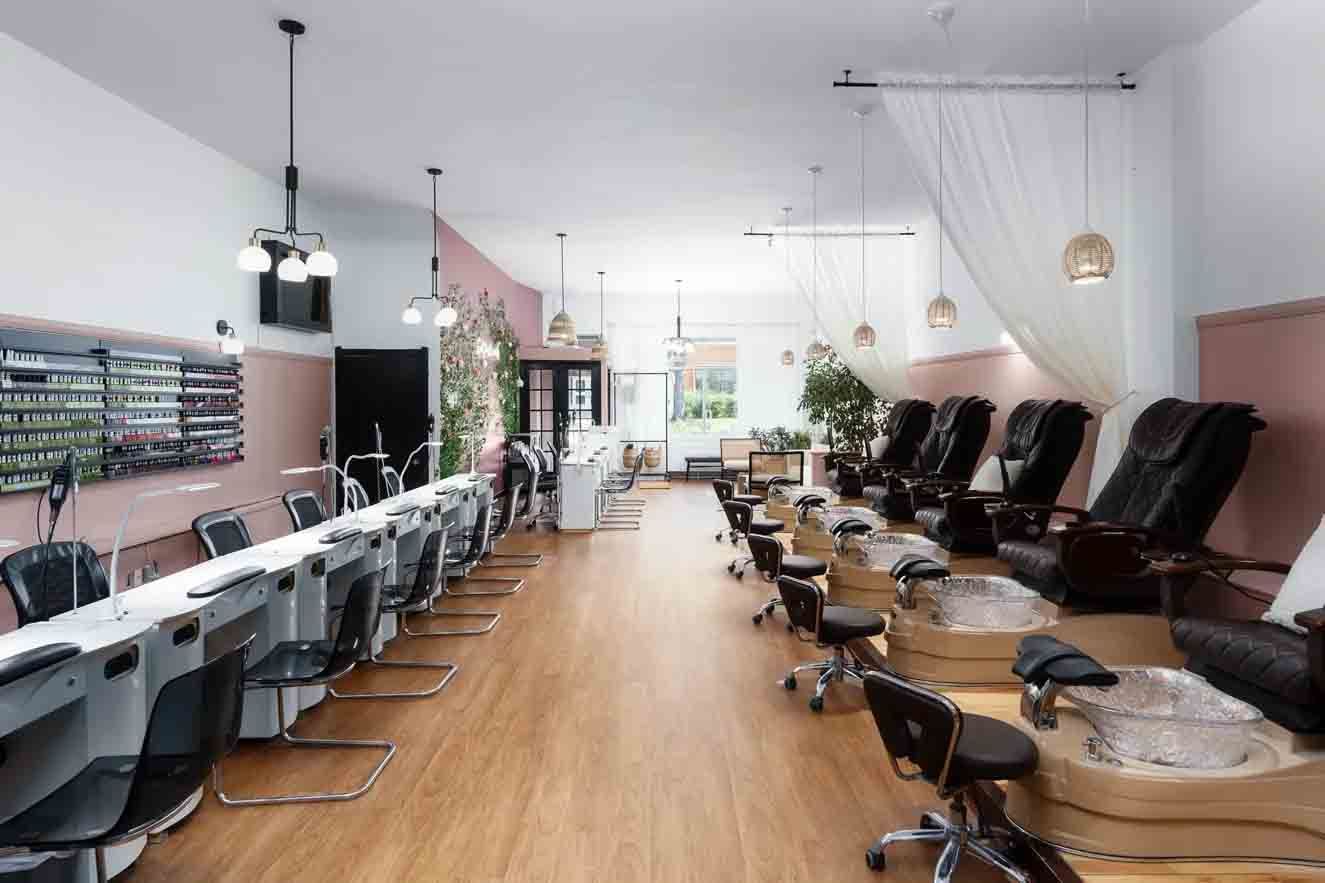 Modern nail salon interior with manicure tables on the left and pedicure chairs on the right