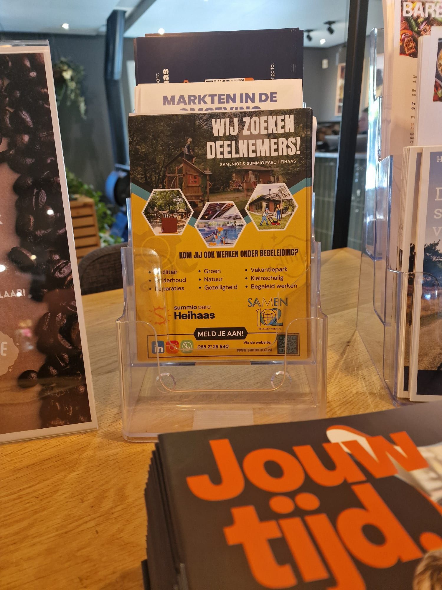 Een folderstand met een flyer in het Nederlands: