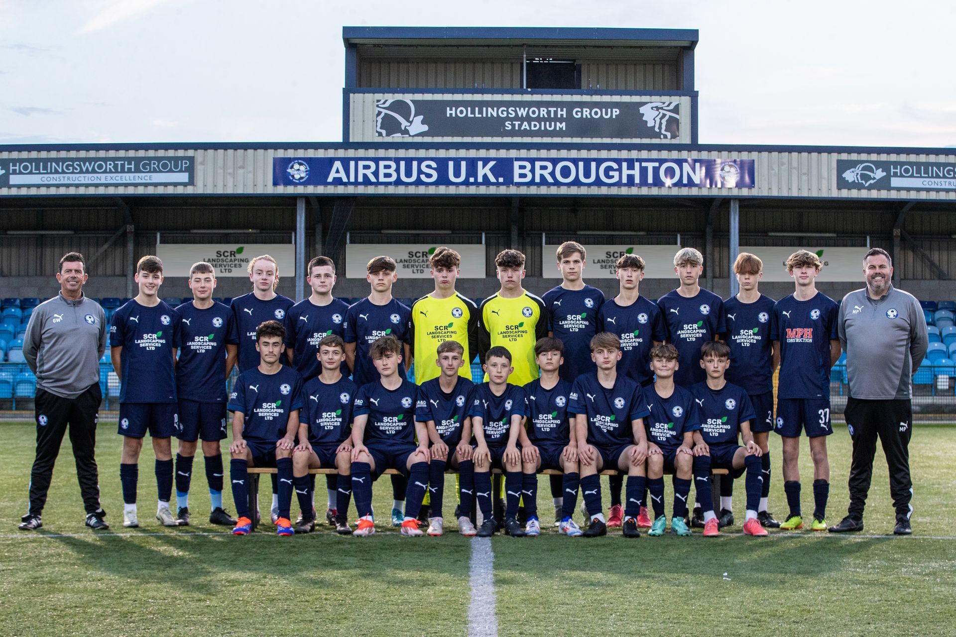 Airbus UK Broughton youth soccer team poses for a group photo in navy and light blue.
