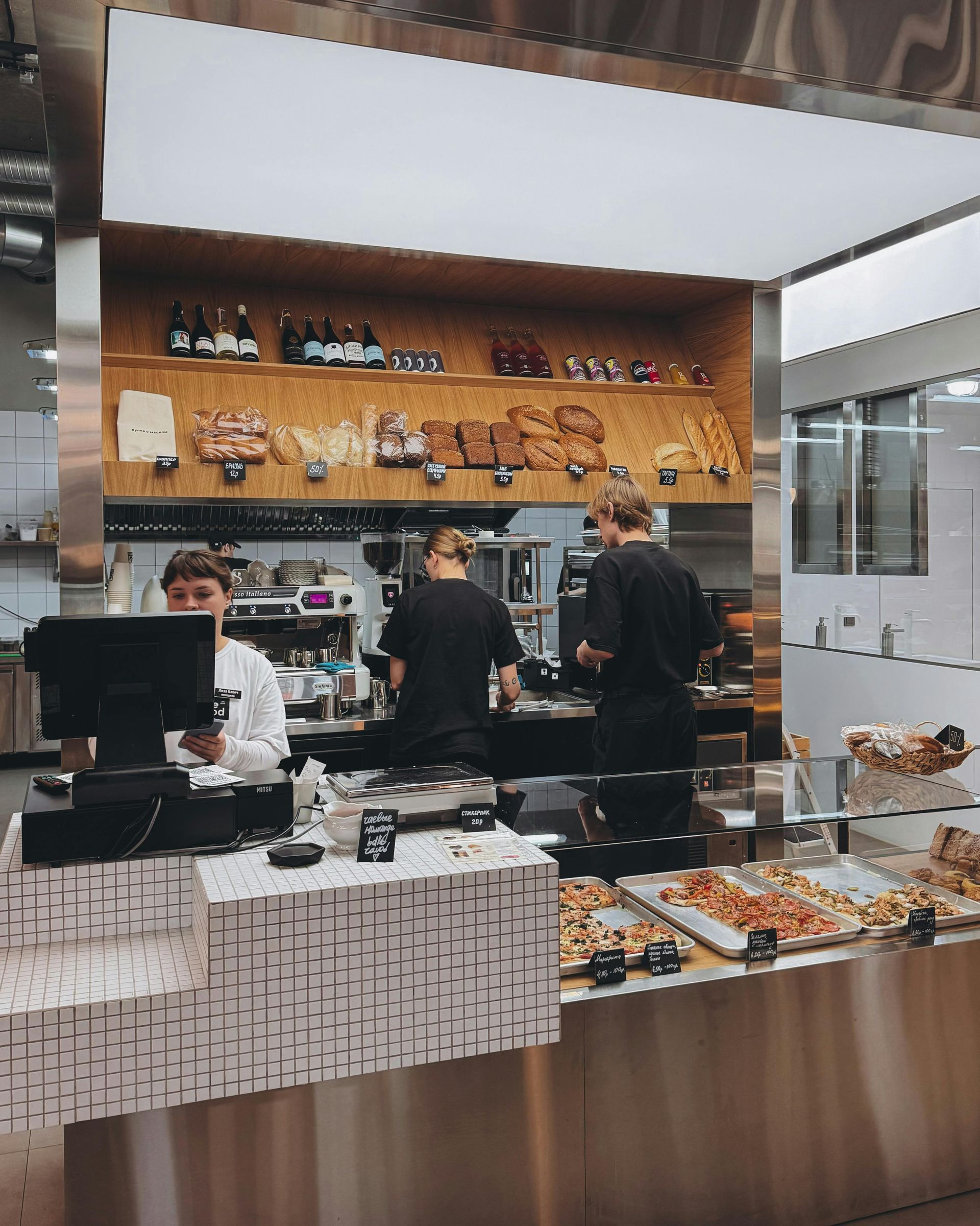 Bakery interior with staff behind a counter. Display of baked goods.