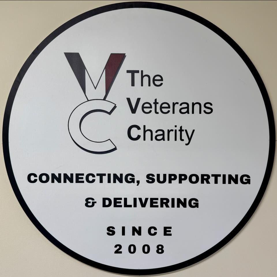 Logo for The Veterans Charity: white circle with black border; text and a