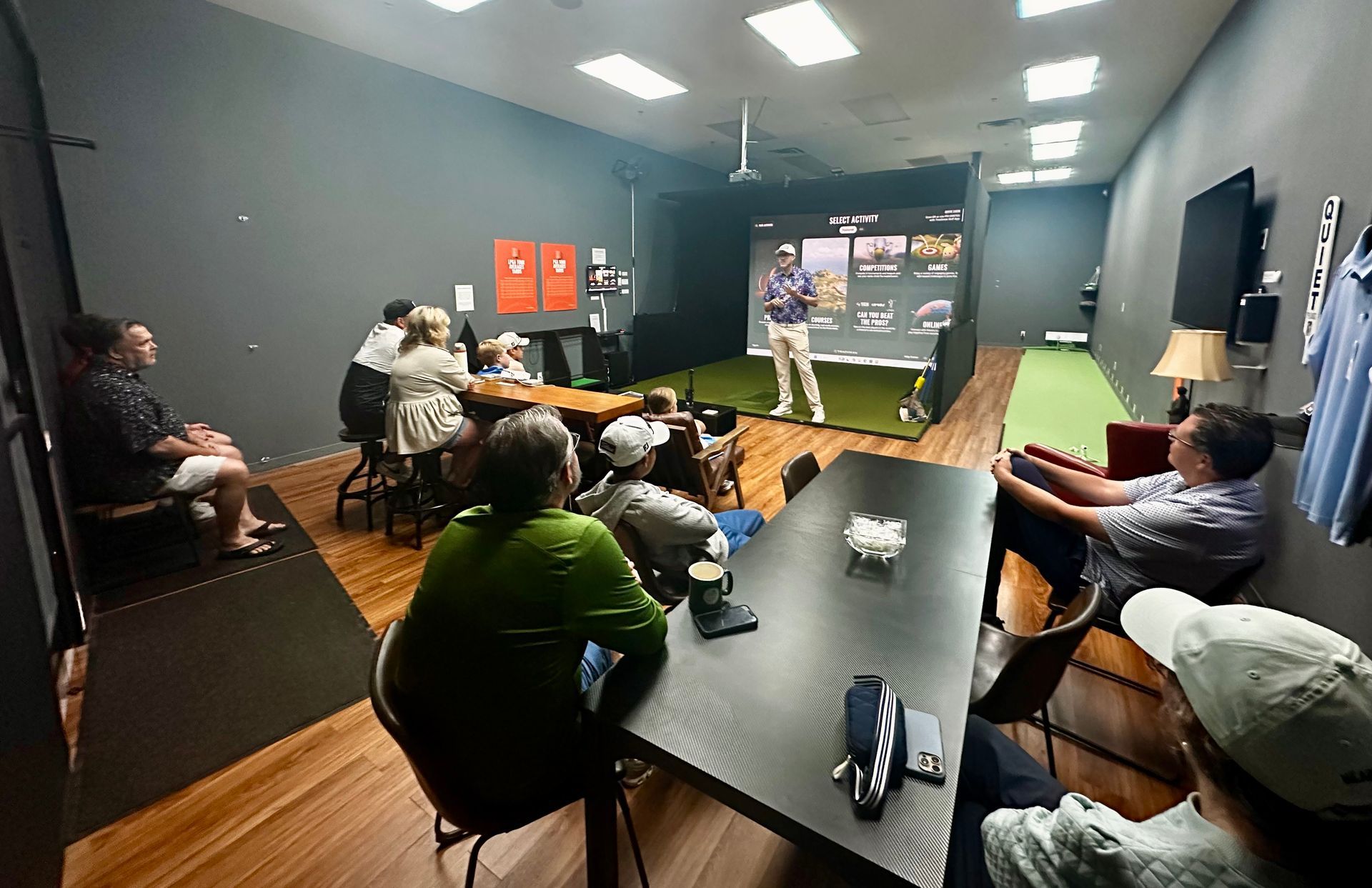People attending a meeting featuring an indoor golf studio at Tee Time Golf in Tulsa, Oklahoma.