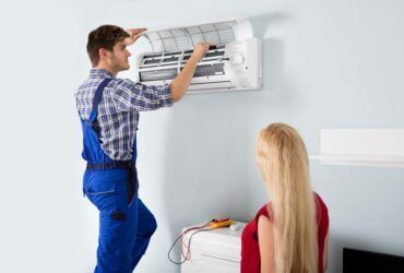 Repairman Works On Apartment Air Conditioning Unit