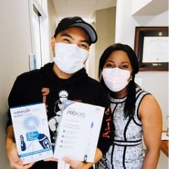 A man and a woman wearing face masks are holding boxes.