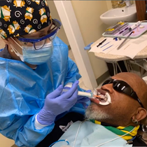 A man is getting his teeth examined by a dentist