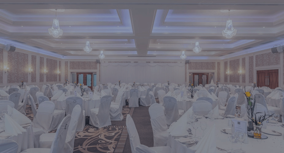 Elegant banquet hall with white-covered tables and chairs set for a formal event